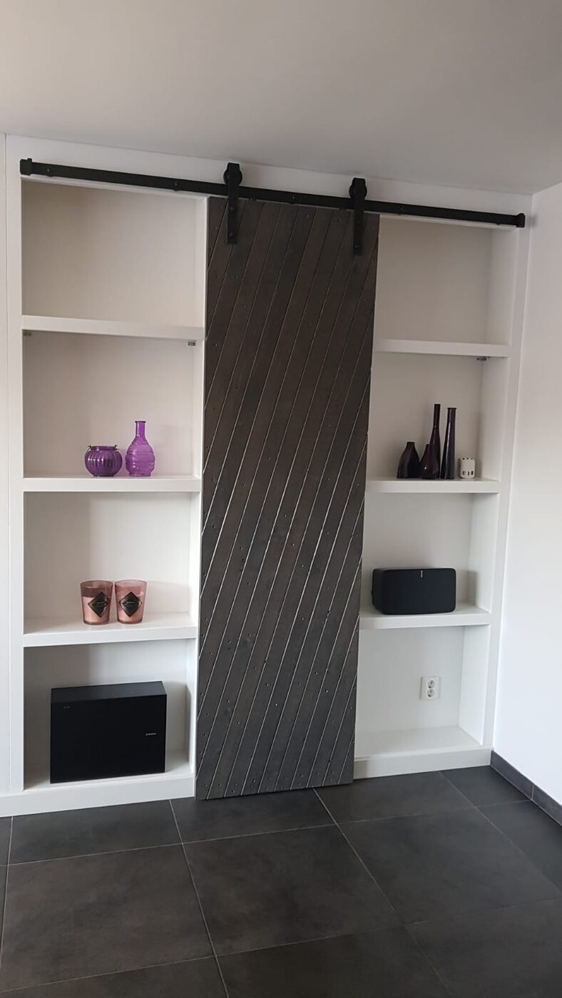 Boekenkast op maat met schuifdeur van verweerd hout