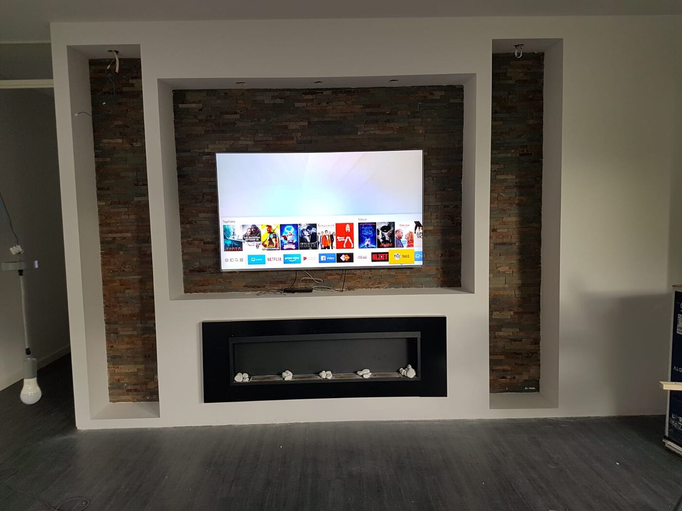 TV-wand met siersteen en ingebouwde sfeerhaard, gemaakt door MK Modulair Bouw